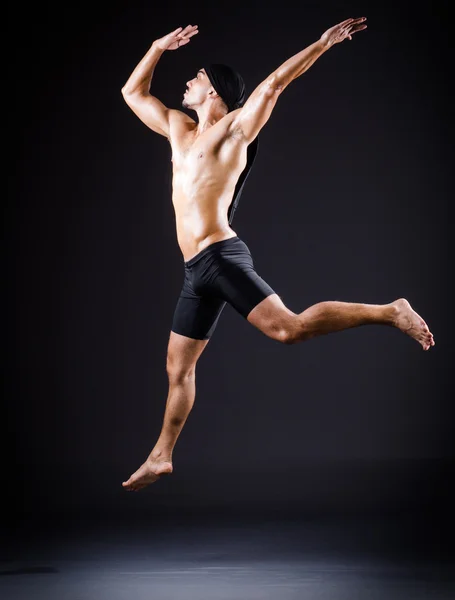 Danser dansen in de donkere studio — Stockfoto