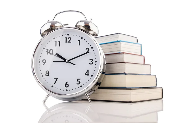 Reloj despertador y libros aislados en blanco — Foto de Stock