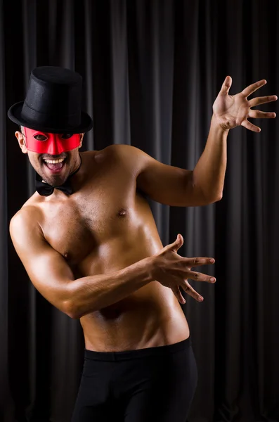 Muscular actor with mask against curtain — Stock Photo, Image