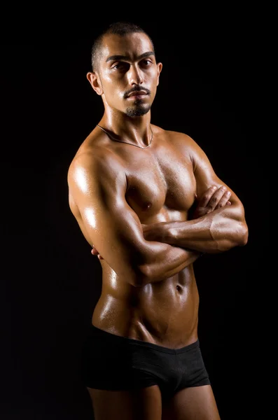 Homem muscular no estúdio escuro — Fotografia de Stock