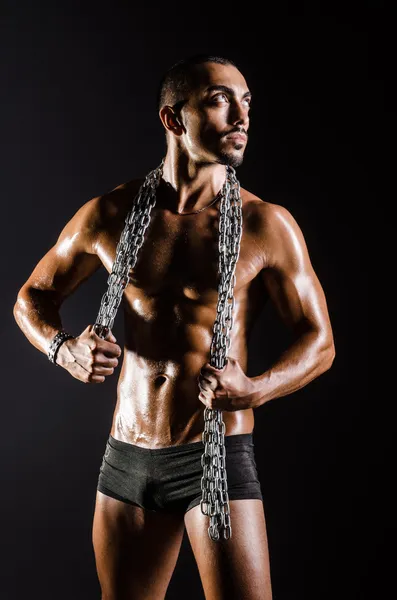 Uomo muscolare con catena su sfondo nero — Foto Stock