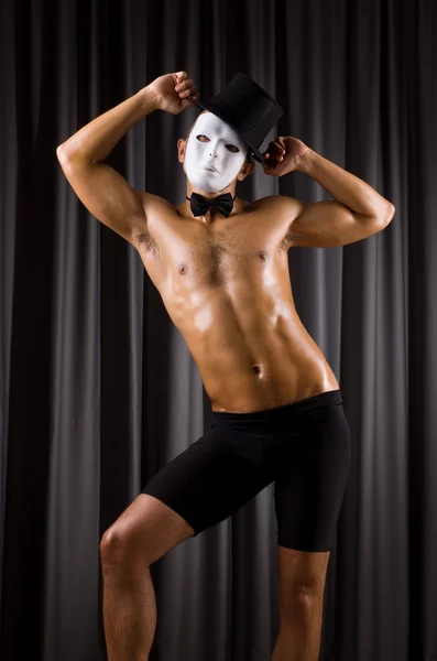 Muscular actor with mask against curtain — Stock Photo, Image