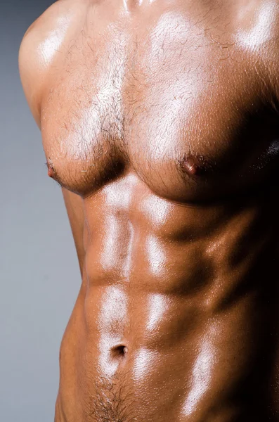 Muscular man in dark studio — Stock Photo, Image