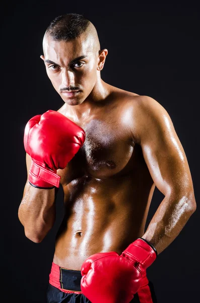 Boxeador con guantes rojos en habitación oscura —  Fotos de Stock