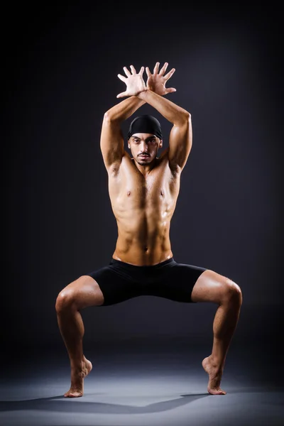 Dancer dancing in the dark studio — Stock Photo, Image