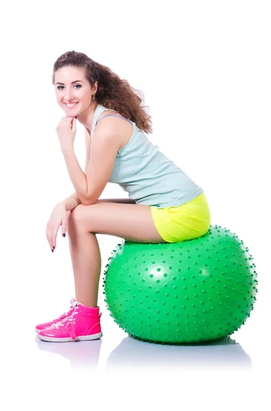 Mujer joven con pelota haciendo ejercicio sobre blanco — Foto de Stock