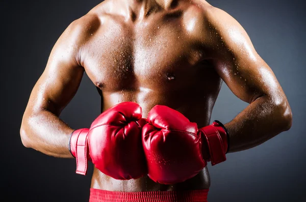 Boxer com luvas vermelhas no quarto escuro — Fotografia de Stock