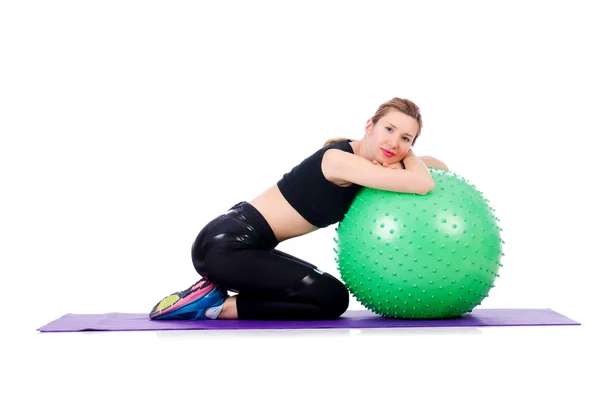 Mujer joven con pelota haciendo ejercicio sobre blanco — Foto de Stock