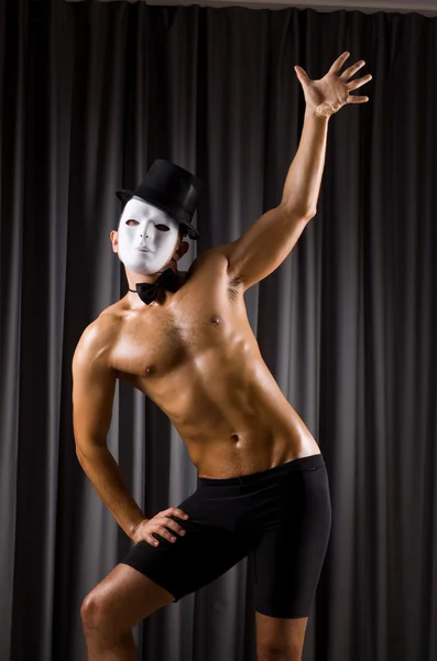 Muscular actor with mask against curtain — Stock Photo, Image