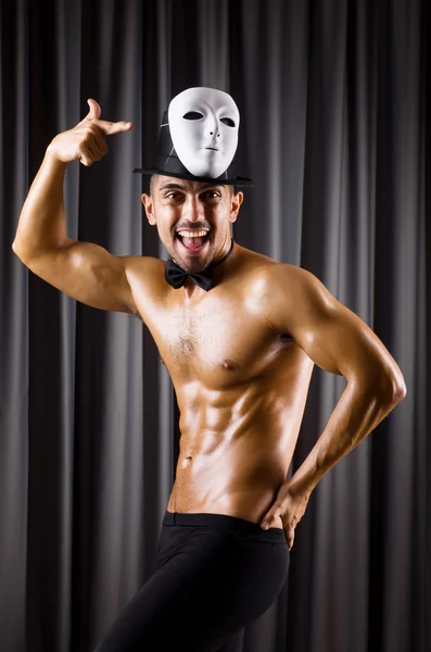 Muscular actor with mask against curtain — Stock Photo, Image