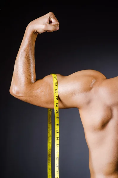 Homme musclé mesurant ses muscles — Photo