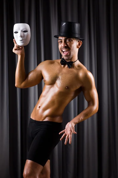 Muscular actor with mask against curtain — Stock Photo, Image