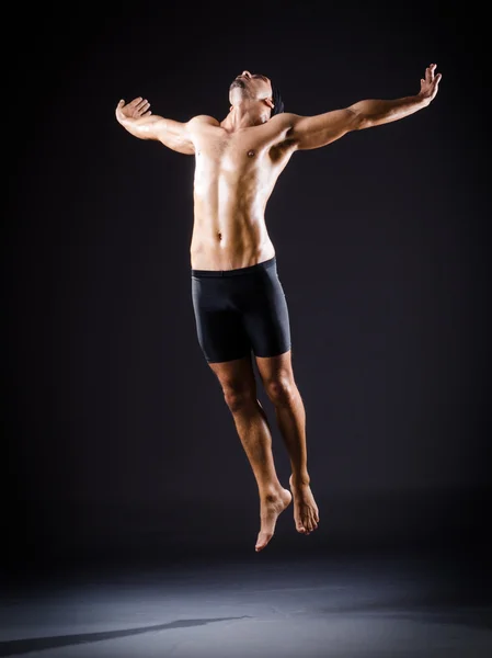 Dancer dancing in the dark studio — Stock Photo, Image