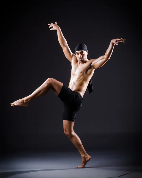 Danser dansen in de donkere studio — Stockfoto