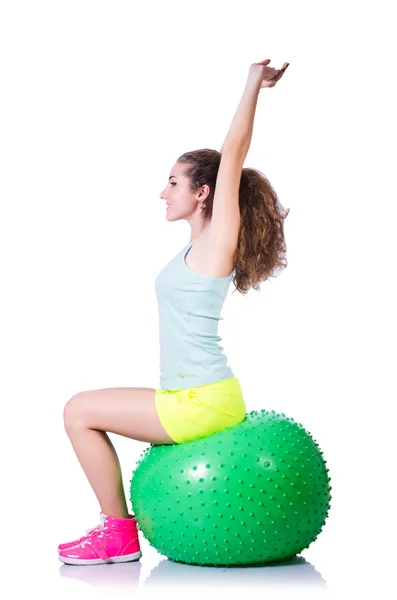 Mujer joven con pelota haciendo ejercicio sobre blanco — Foto de Stock