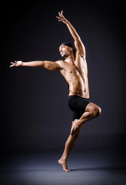 Danser dansen in de donkere studio — Stockfoto