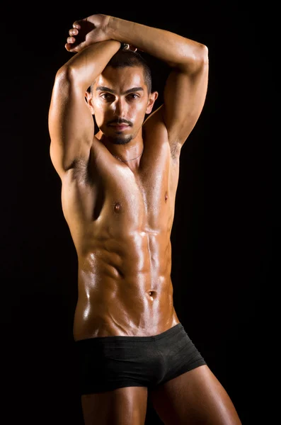 Uomo muscoloso in studio scuro — Foto Stock