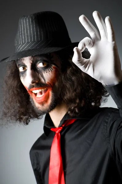 Joker personification with man in dark room — Stock Photo, Image