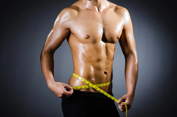 Мускулистый человек измеряет свои мышцы — стоковое фото