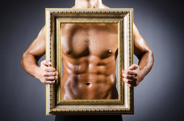 Muscular man with picture frame — Stock Photo, Image