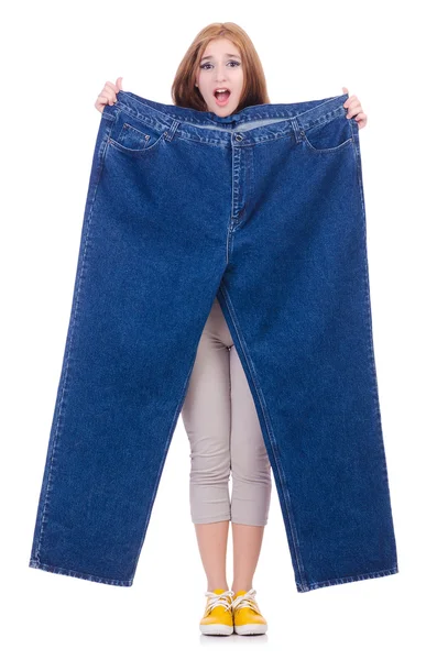 Kvinna i bantningskoncept med stora jeans — Stockfoto