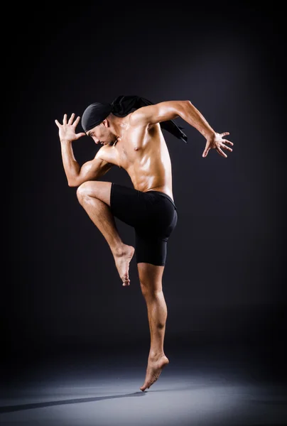 Танцовщица танцует в темной студии — стоковое фото