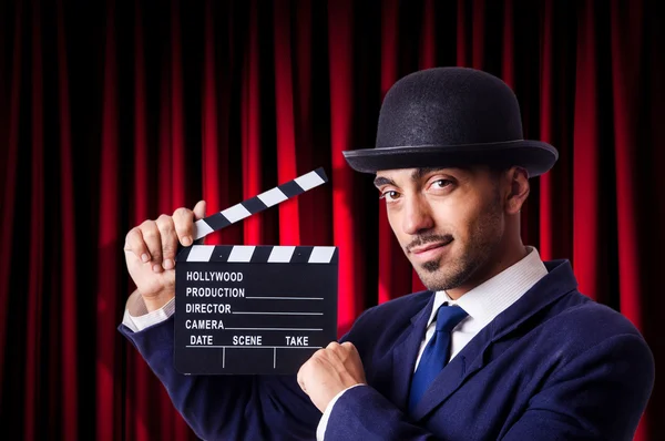 Hombre con película clapper en fondo de cortina —  Fotos de Stock