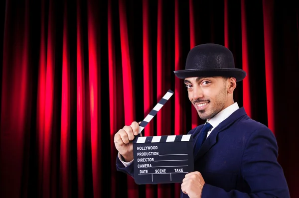 Hombre con película clapper en fondo de cortina — Foto de Stock