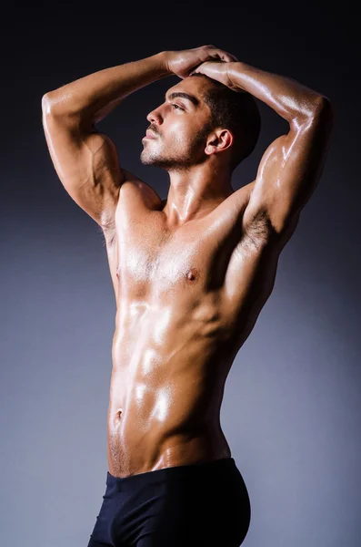 Muscular man in dark studio — Stock Photo, Image