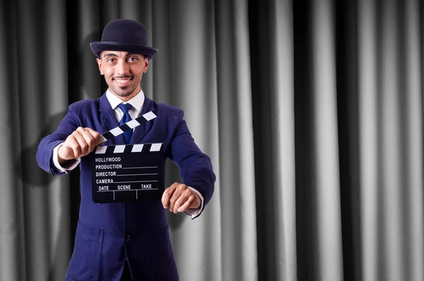 Man with movie clapper on curtain background — Stock Photo, Image