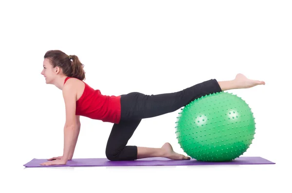 Mujer joven con pelota haciendo ejercicio sobre blanco — Foto de Stock