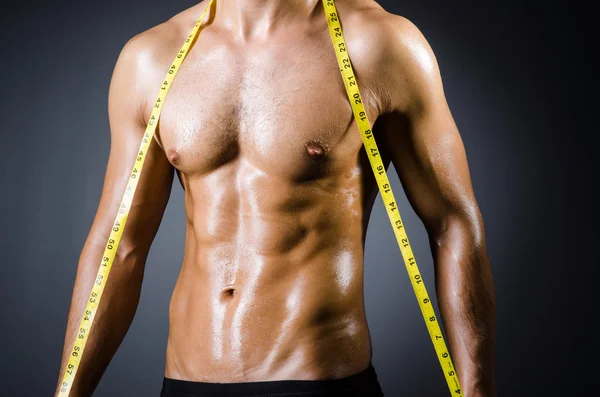 Homme musclé mesurant ses muscles — Photo