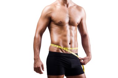 Kaslı adam kaslarını ölçüyor.