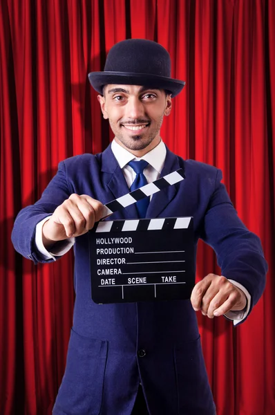 Man with movie clapper on curtain background — Stock Photo, Image