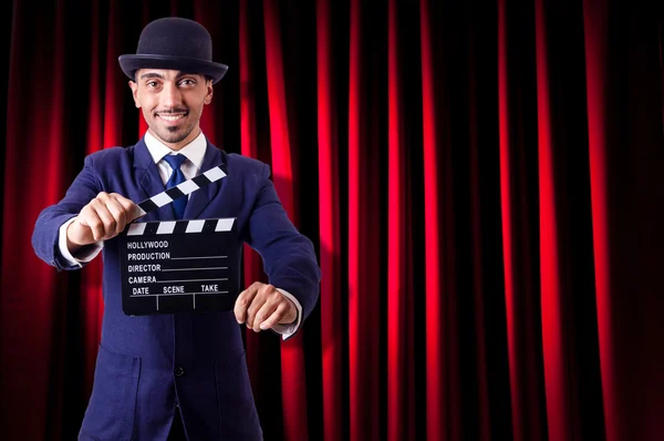 Hombre con película clapper en fondo de cortina — Foto de Stock