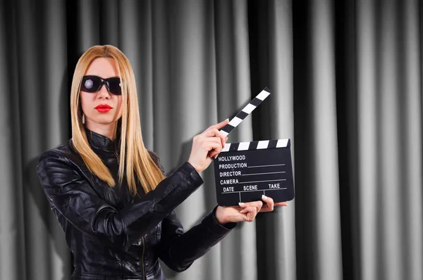 Ragazza con scheda film contro le tende — Foto Stock