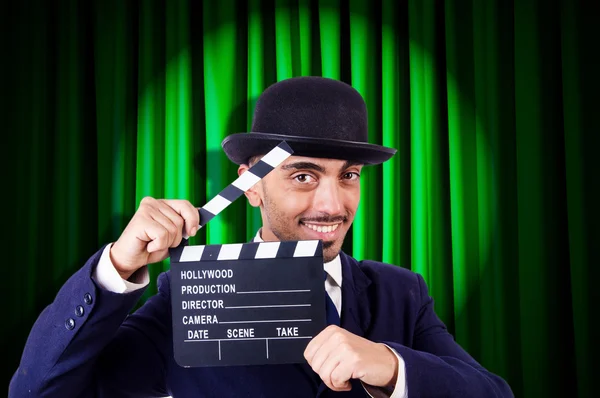 Hombre con película clapper en fondo de cortina — Foto de Stock