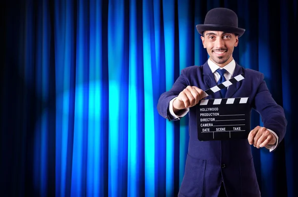 Hombre con película clapper en fondo de cortina — Foto de Stock