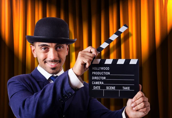 Hombre con película clapper en fondo de cortina — Foto de Stock