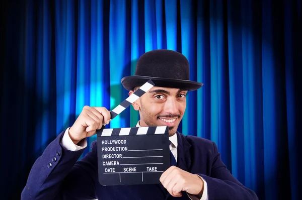 Hombre con película clapper en fondo de cortina — Foto de Stock