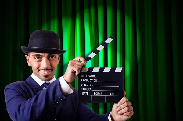 Hombre con película clapper en fondo de cortina — Foto de Stock