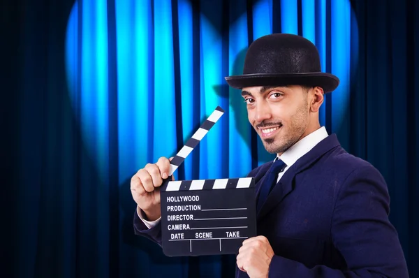 Hombre con película clapper en fondo de cortina —  Fotos de Stock