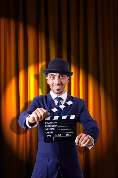 Hombre con película clapper en fondo de cortina — Foto de Stock
