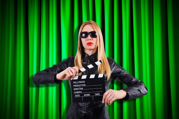 Flicka med film styrelsen mot gardiner — Stockfoto