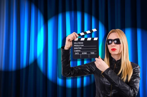 Menina com placa de filme contra cortinas — Fotografia de Stock