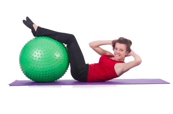 Mujer joven con pelota haciendo ejercicio sobre blanco — Foto de Stock