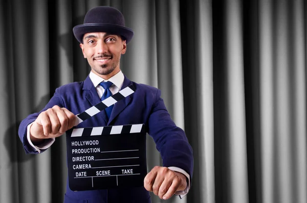 Hombre con película clapper en fondo de cortina —  Fotos de Stock