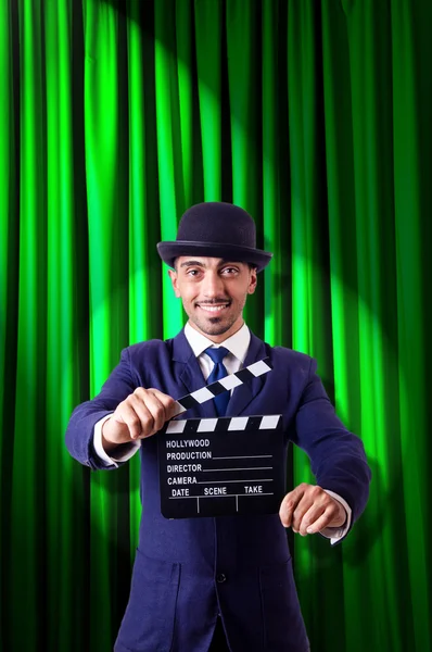 Hombre con película clapper en fondo de cortina — Foto de Stock