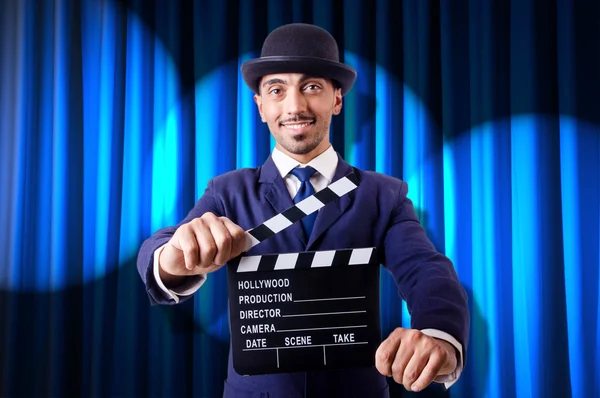 Man with movie clapper on curtain background — Stock Photo, Image