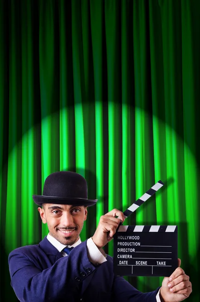 Mann mit Filmklöppel auf Vorhang-Hintergrund — Stockfoto